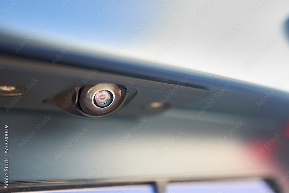 Luxury car rear view camera for parking assistance selective focus close up with sunflare and copyspace. Concept of safety car driving while parking process. Assist device equipment in modern cars. Luxury car rear view camera for parking assistance selective focus close up with sunflare and copyspace. Concept of safety car driving while parking process. Assist device equipment in modern cars.