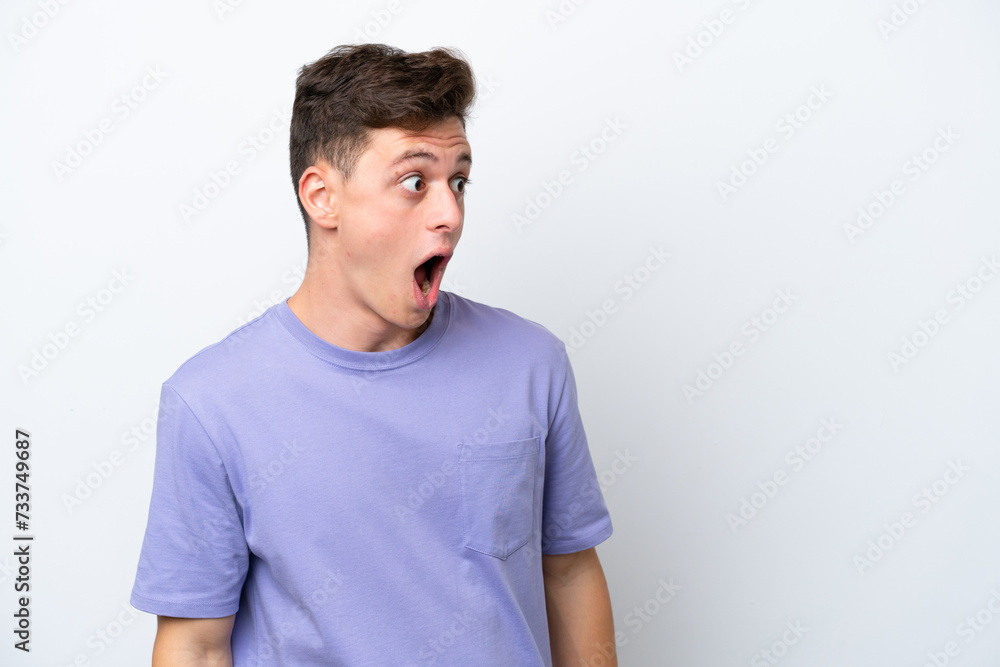 Young handsome Brazilian man isolated on white background doing surprise gesture while looking to the side Young handsome Brazilian man isolated on white background doing surprise gesture while looking to the side