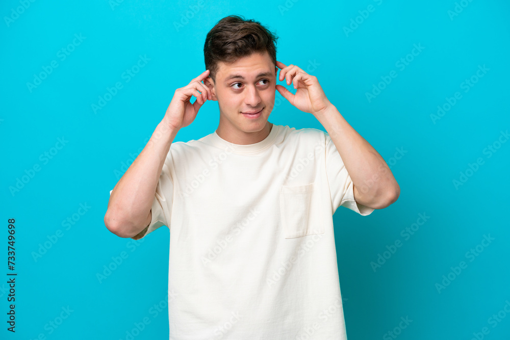 Fototapeta premium Young handsome Brazilian man isolated on blue background having doubts and thinking