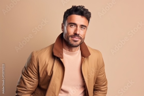 Portrait of a handsome young man in a brown jacket. Men's beauty, fashion.