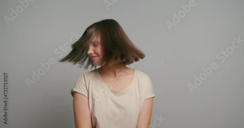 Adolescence happiness. Carefree latin teenager dancing. Cheerful hispanc girl on gray background photo