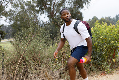 Close Up Photo of Wandering Black African American Holding a Yellow Tumbler While Hiking in Rocky Mountain during Daylight