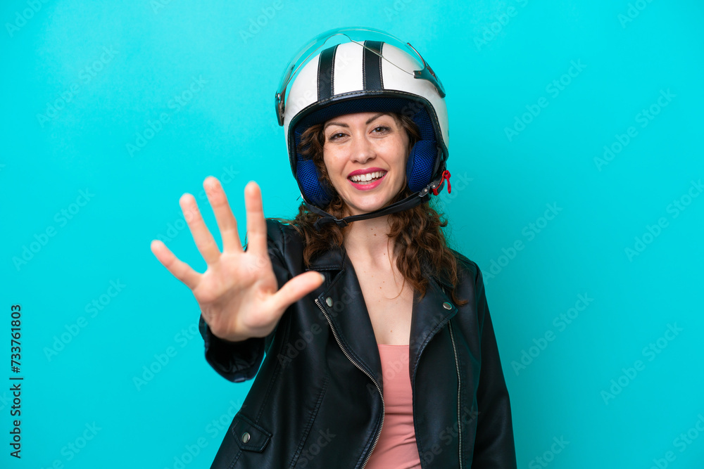 Young caucasian woman with a motorcycle helmet isolated on blue background counting five with fingers Young caucasian woman with a motorcycle helmet isolated on blue background counting five with fingers