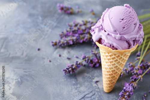 lavender ice cream in a cone with lavade flowers with copy space on the left on a gray background