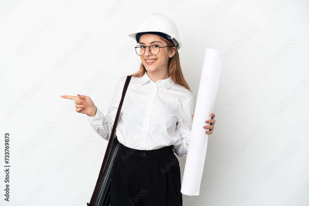 Young architect woman with helmet and holding blueprints isolated on white background pointing finger to the side Young architect woman with helmet and holding blueprints isolated on white background pointing finger to the side