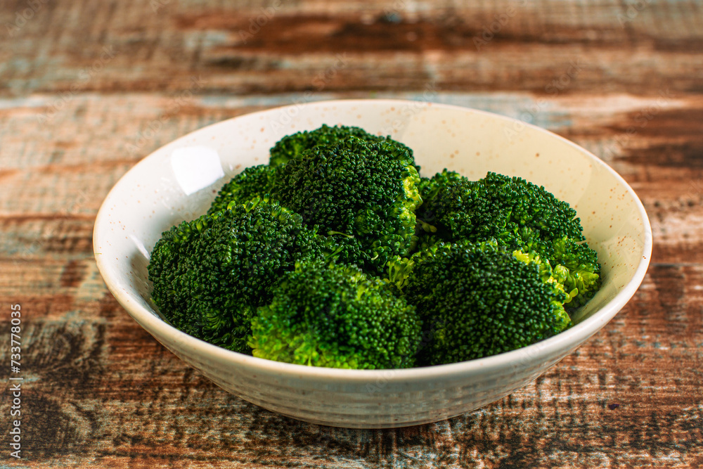 Steamed broccoli in a bowl on a rustic table Steamed broccoli in a bowl on a rustic table