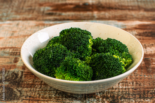 Steamed broccoli in a bowl on a rustic table