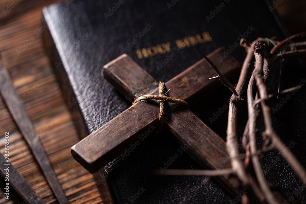 Christian cross with crown thorns and bible on dark desk. Christian cross with crown thorns and bible on dark desk.