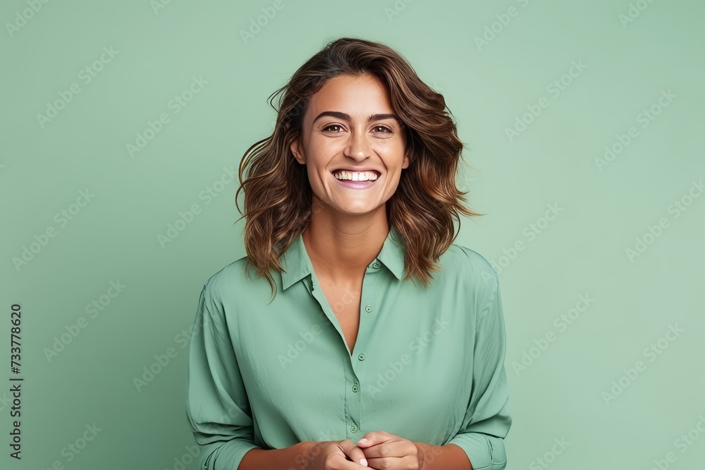 Portrait of a happy young woman smiling at the camera over green background Portrait of a happy young woman smiling at the camera over green background