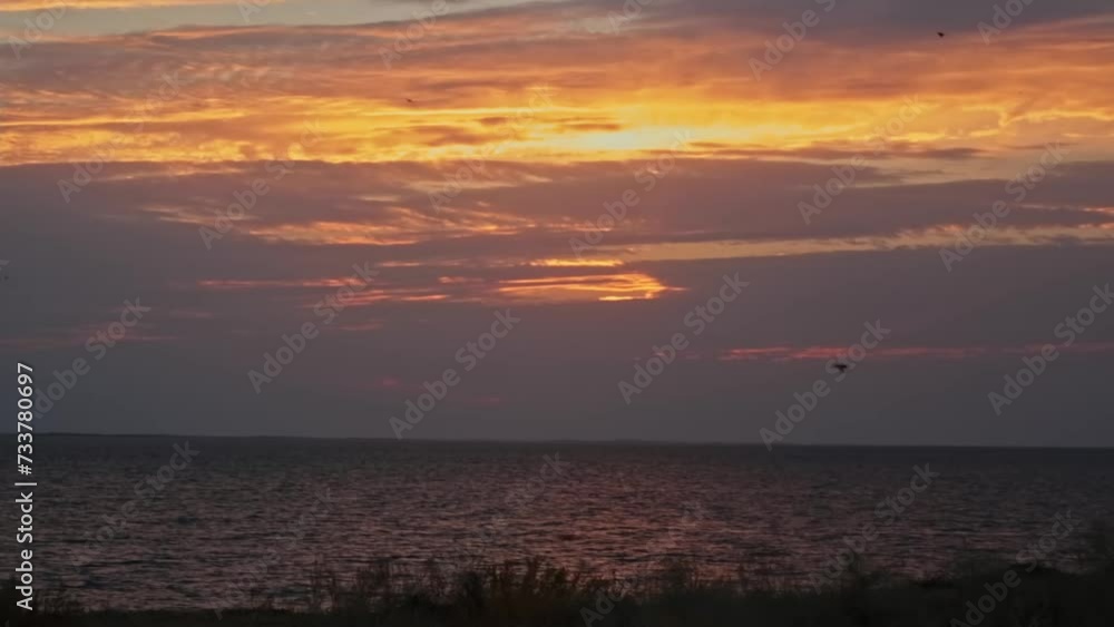 Green hills against the background of the river in the rays of the sunset. A cloudy summer evening.