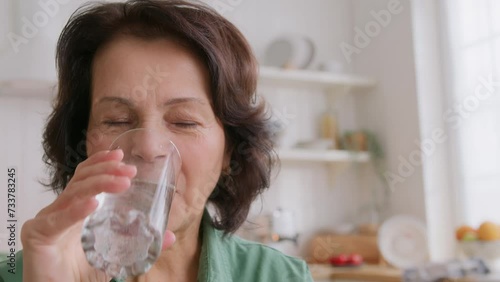 close up view of elderly woman holding pill on hand, takes medicine and drink water. feels good and positive, smiling. old people medicare