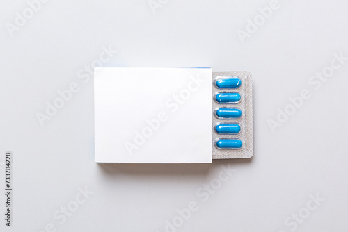 Blank White Product Package Box Mock-up. Open blank medicine drug box with blue pills blister top view photo