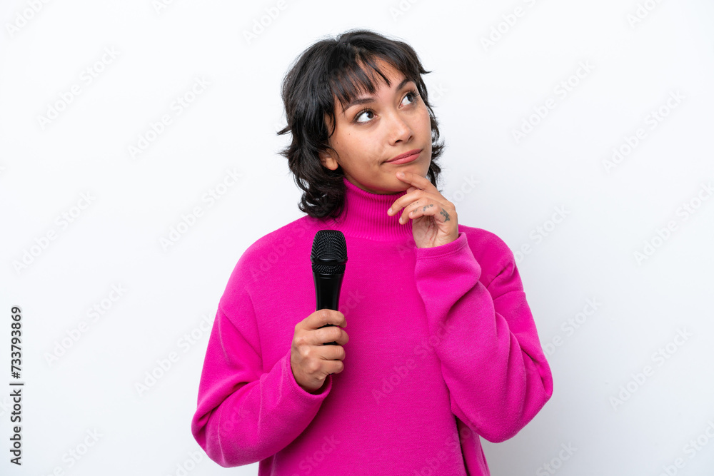Young Argentinian singer woman isolated on white background having doubts while looking up Young Argentinian singer woman isolated on white background having doubts while looking up