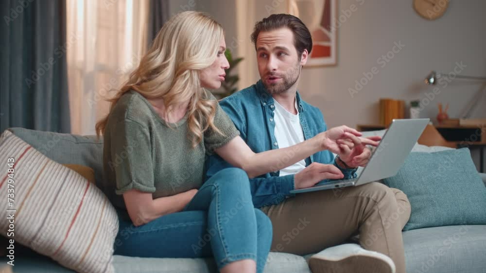 Colleagues sitting on couch and talking actively. Man and woman sitting on sofa. Male and female working on business project. Man and woman solving work issues. Business colleagues using laptop. Colleagues sitting on couch and talking actively. Man and woman sitting on sofa. Male and female working on business project. Man and woman solving work issues. Business colleagues using laptop.