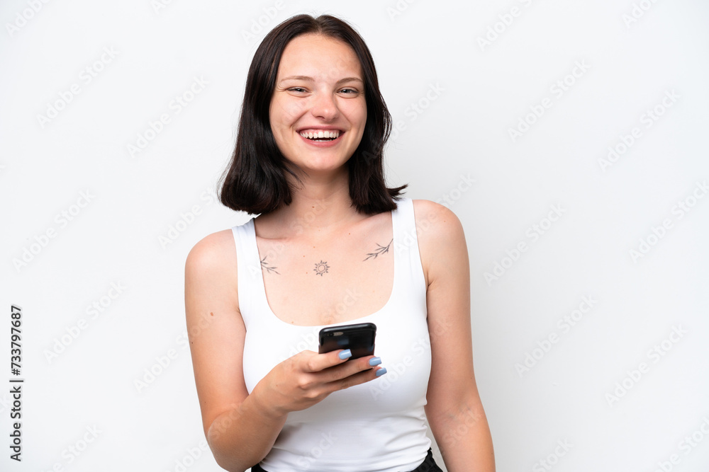Young caucasian woman isolated on white background using mobile phone
