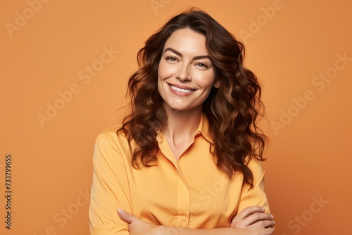 Portrait of happy smiling young business woman, over orange background.