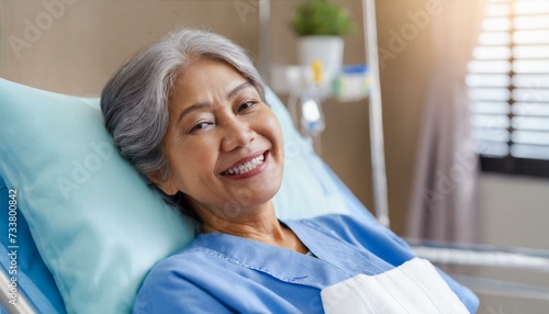  A Senior female patient lying satisfied smiling at modern hospital patient bed. health medical