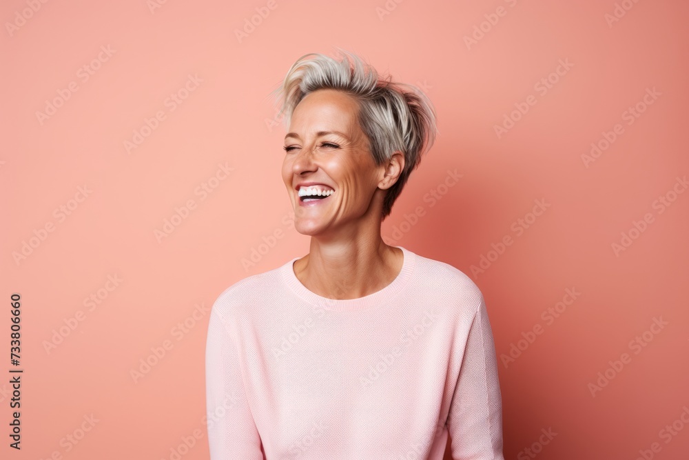Portrait of happy senior woman laughing and looking at camera against pink background Portrait of happy senior woman laughing and looking at camera against pink background