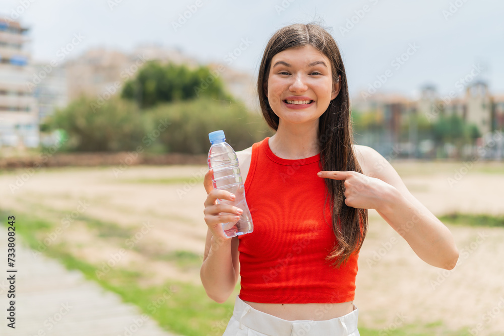 Young pretty Ukrainian woman with a bottle of water at outdoors with surprise facial expression Young pretty Ukrainian woman with a bottle of water at outdoors with surprise facial expression