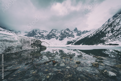 Frozen lake Morske Oko surrounded by stunning mountains in Tatra national par...