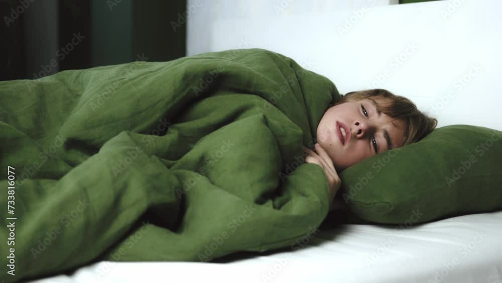 Close up view of kid having bad cough , sneezing and chest pain at home. Teenager boy being ill while lying in bed with blanket. Concept of healthcare and illness. Close up view of kid having bad cough , sneezing and chest pain at home. Teenager boy being ill while lying in bed with blanket. Concept of healthcare and illness.