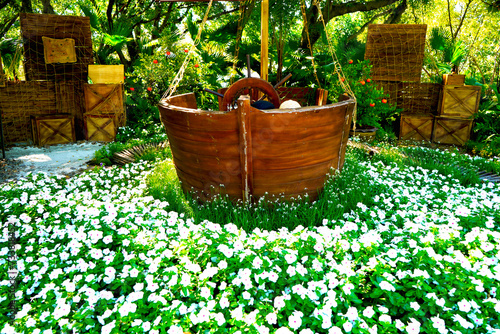 The garden is beautiful with sailboats surrounded by white flowers resembling waves in the sea. 