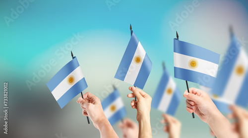 A group of people are holding small flags of Argentina in their hands. photo