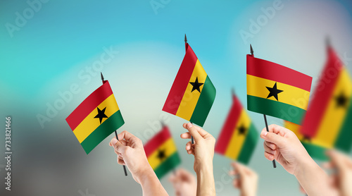 Fototapeta Naklejka Na Ścianę i Meble -  A group of people are holding small flags of Ghana in their hands.