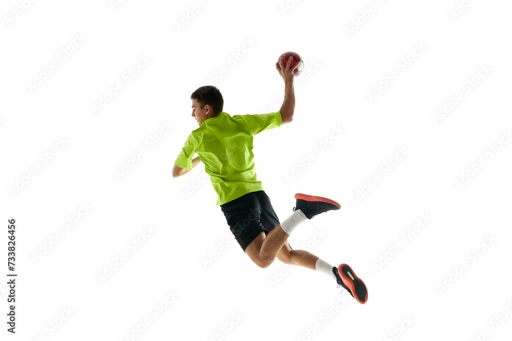 Competitive and concentrated young guy, handball player in motion during game, training against white studio background. Concept of professional sport, tournament, competition