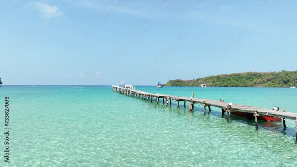 The wooden jetty leads out to the sea with blue turquoise sea water scene in summer tropical background The wooden jetty leads out to the sea with blue turquoise sea water scene in summer tropical background