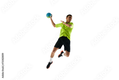 Dynamic image of young man in uniform, handball player in motion during game, practicing, jumping with ball against white studio background. Concept of professional sport, tournament, competition