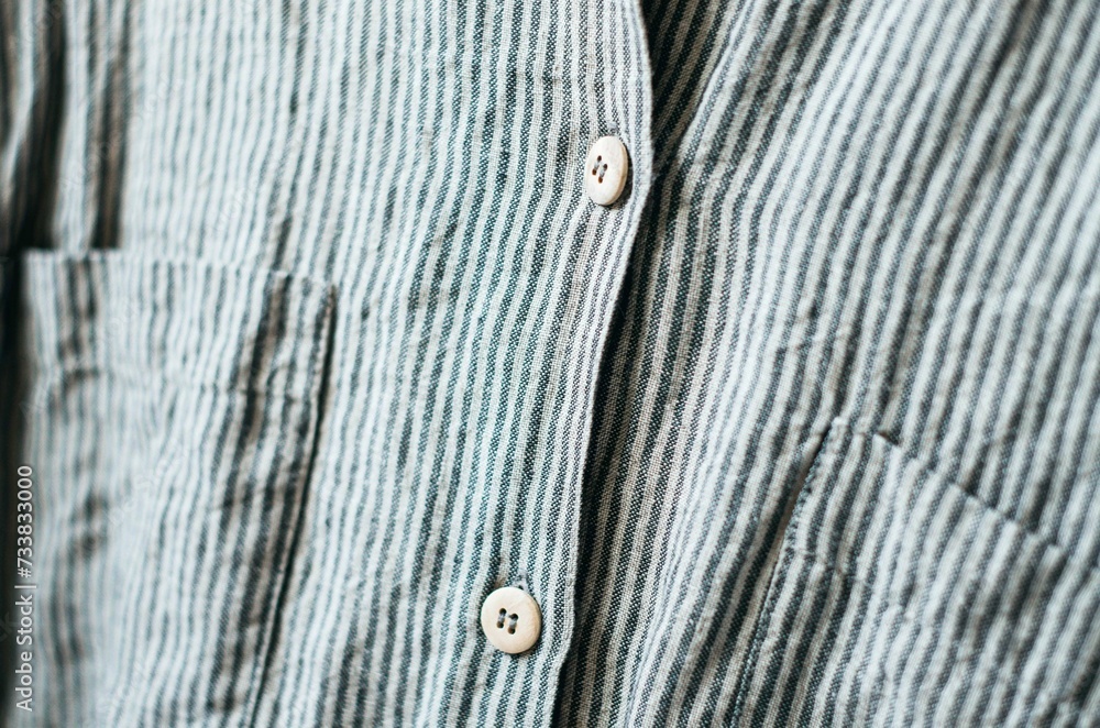 Close up wooden button on linen grey stripes shirt Close up wooden button on linen grey stripes shirt