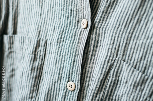 Close up wooden button on linen grey stripes shirt