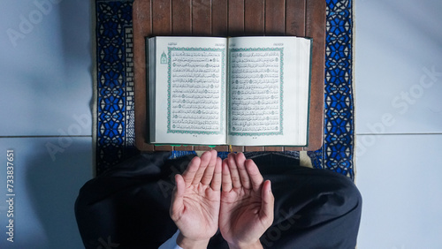 Top view of a Muslim man reading the Quran and prayer