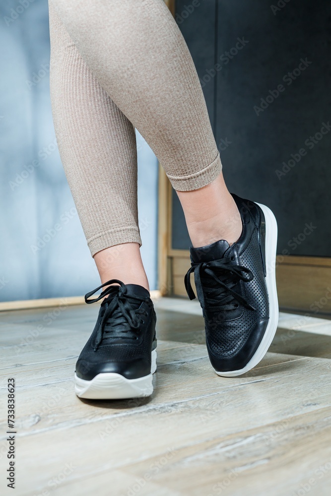 Black women's sneakers. Collection of women's leather shoes. Female legs in leather black casual sneakers. Stylish women's sneakers. Black women's sneakers. Collection of women's leather shoes. Female legs in leather black casual sneakers. Stylish women's sneakers.
