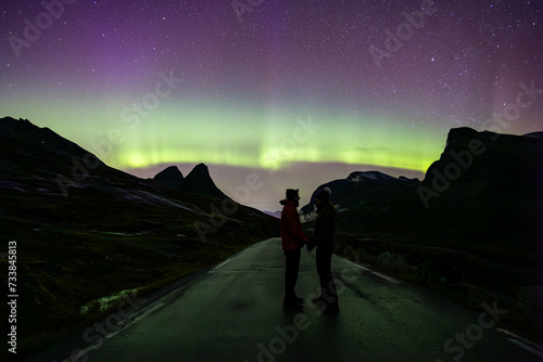 Northern lights and couple in Trollstigen road  South Norway  Europe