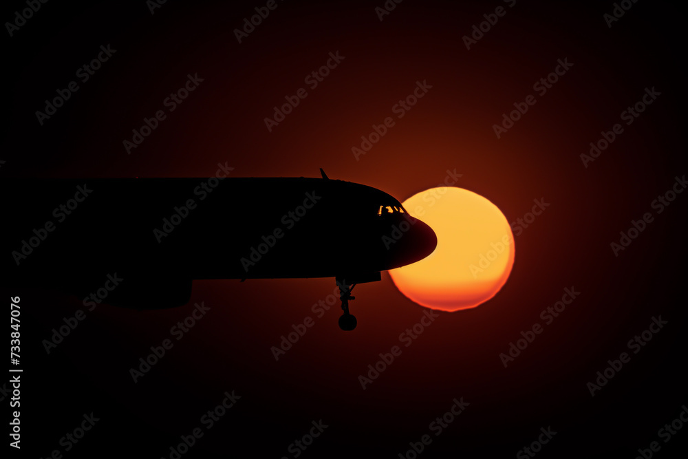 Fototapeta premium Plane gracefully soars through the sunset sky, AI-generated.