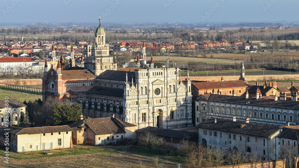 Aerial shot over Certosa di Pavia monastery with lawn fields in Italy, Pavia