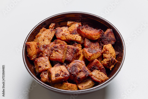 Pieces of fried pork meat, ready to eat in a bowl.
