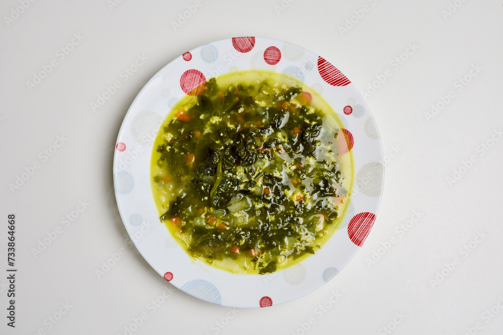 spinach soup in a plate on a table. spinach soup in a plate on a table.