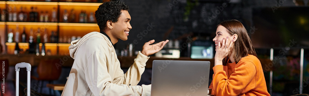 diverse couple working on a project together, black man and woman chatting near laptop, banner diverse couple working on a project together, black man and woman chatting near laptop, banner