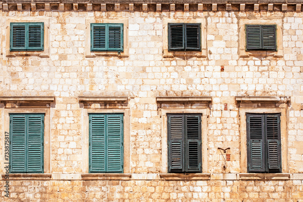 ancient windows with green shutters in an ancient Roman masonry building