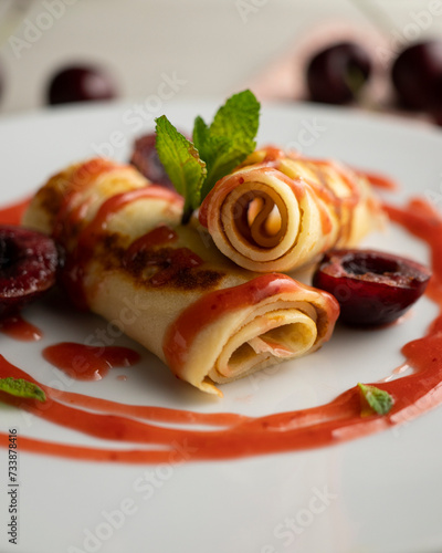 Delicious French crepes with fresh cherries and red fruit syrup.