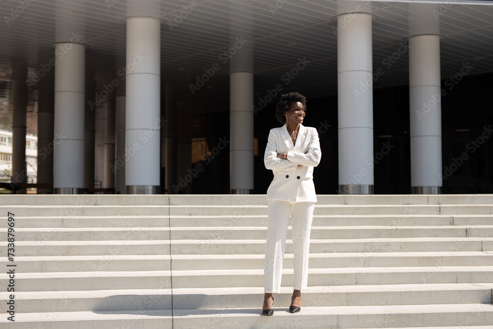 portrait of a happy curly African woman in a white suit portrait of a happy curly African woman in a white suit