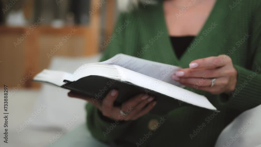Woman reading book alone in quite morning. Hand turns book pages. Self education concept. Senior retired woman female holding a book reading a bible Gospel. Having rest at home reading literature Woman reading book alone in quite morning. Hand turns book pages. Self education concept. Senior retired woman female holding a book reading a bible Gospel. Having rest at home reading literature