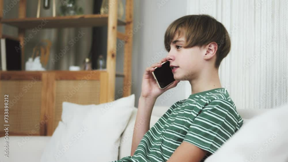 Happy young teenage boy using mobile phone indoor. Caucasian millennial student sending voice message on cellphone, talking on phone with friends, using smartphone for call Happy young teenage boy using mobile phone indoor. Caucasian millennial student sending voice message on cellphone, talking on phone with friends, using smartphone for call