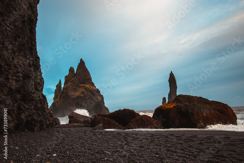 Malerische Felsnadeln an der Küste mit schwarzem Sandstrand