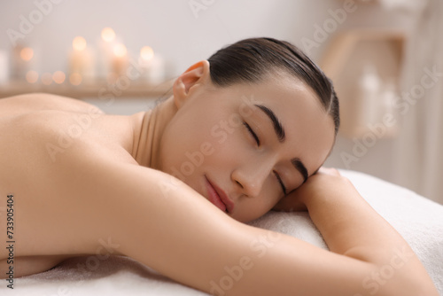 Beautiful woman relaxing on massage couch in spa salon