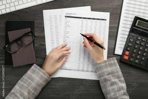Bild auf Leinwand Woman working with accounting documents at wooden table, top view