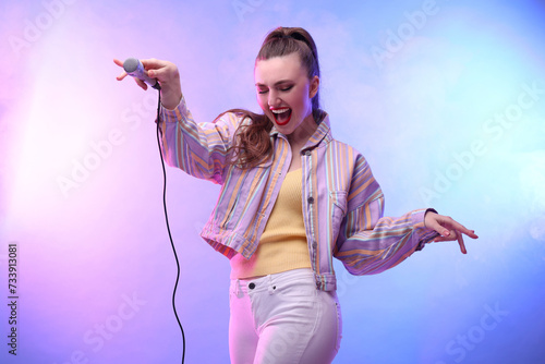 Emotional singer with microphone performing in color lights